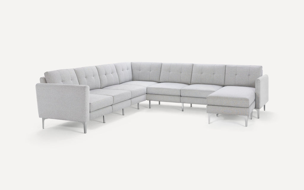 Light gray modern sectional sofa with tufted cushions, clean lines, and metal legs, arranged in an L-shape with a chaise lounge.