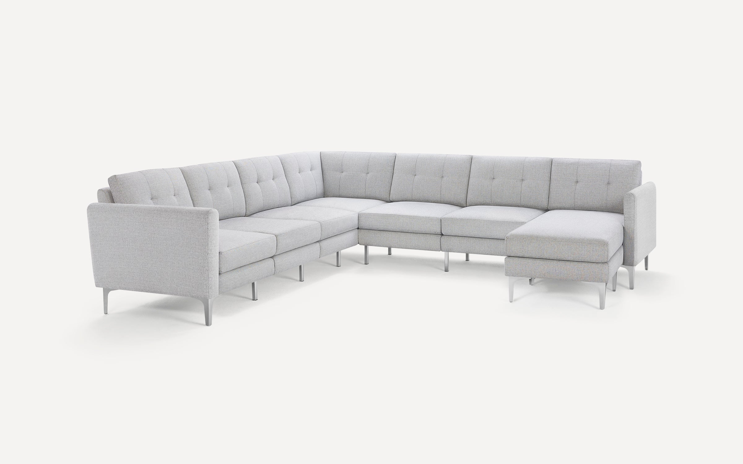Light gray modern sectional sofa with tufted cushions, clean lines, and metal legs, arranged in an L-shape with a chaise lounge.