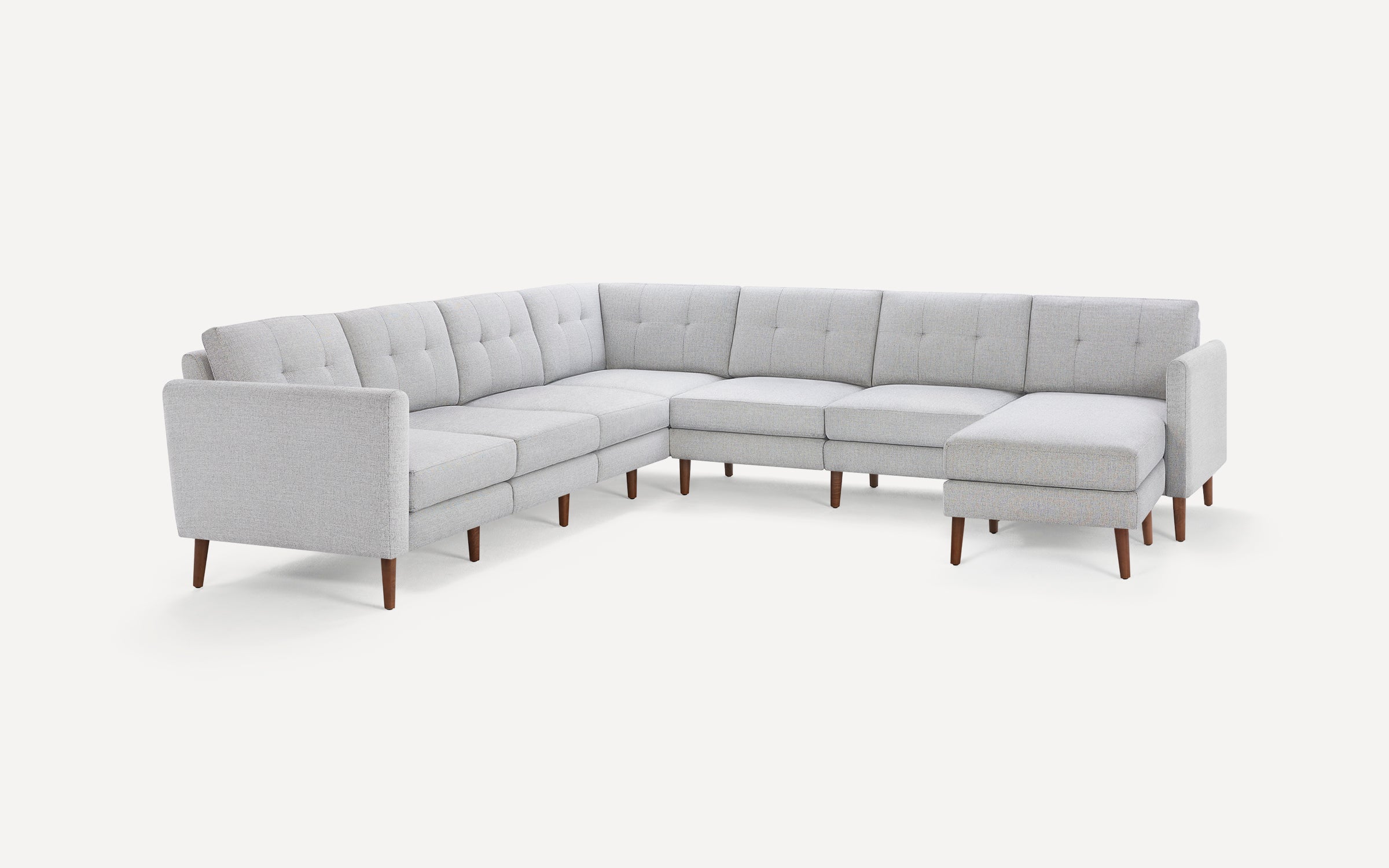 Light gray modern sectional sofa with tufted cushions and wooden tapered legs on a white background.