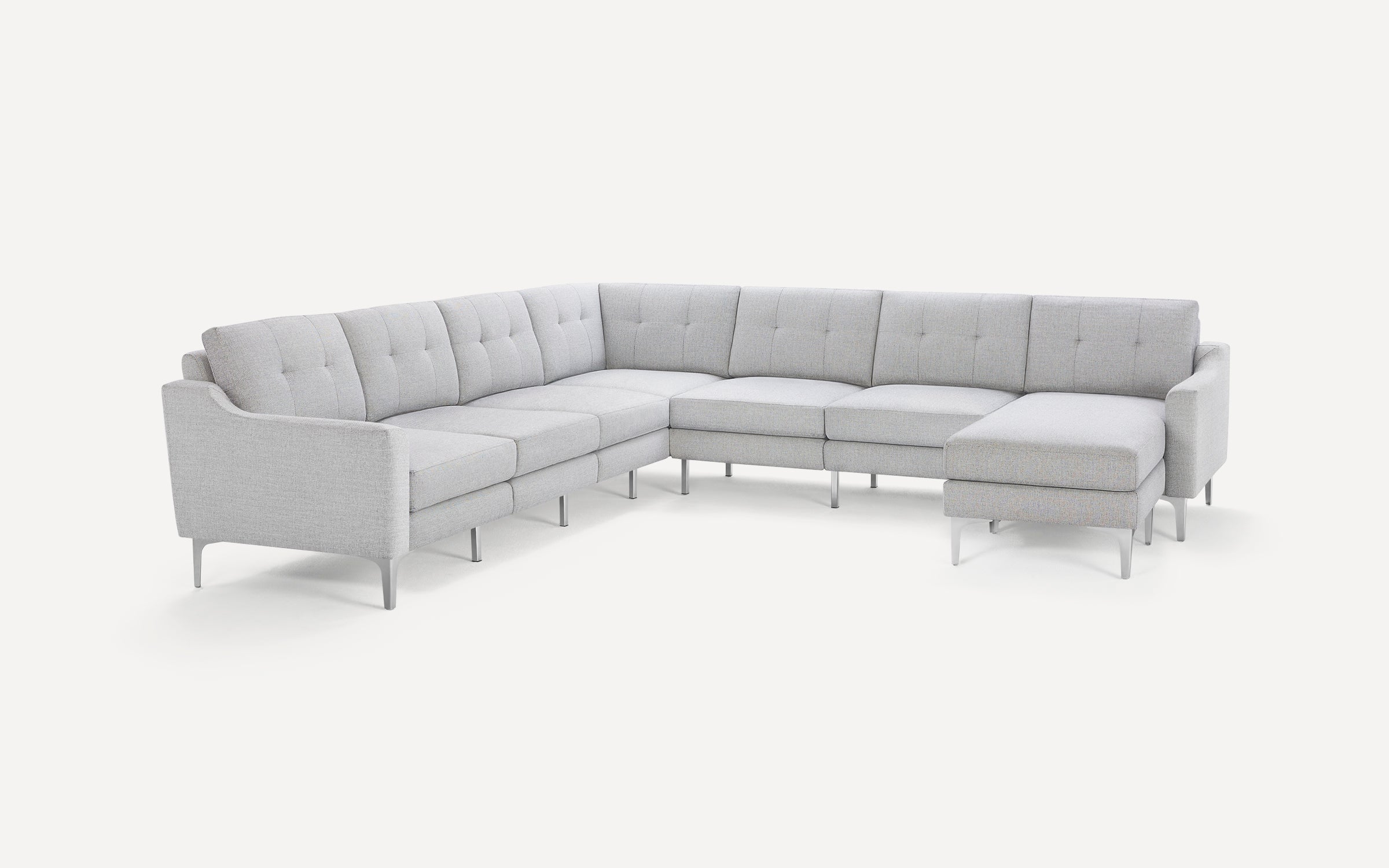 Light gray fabric sectional sofa with modern tufted back cushions, slim angled arms, and metal legs on a white background.