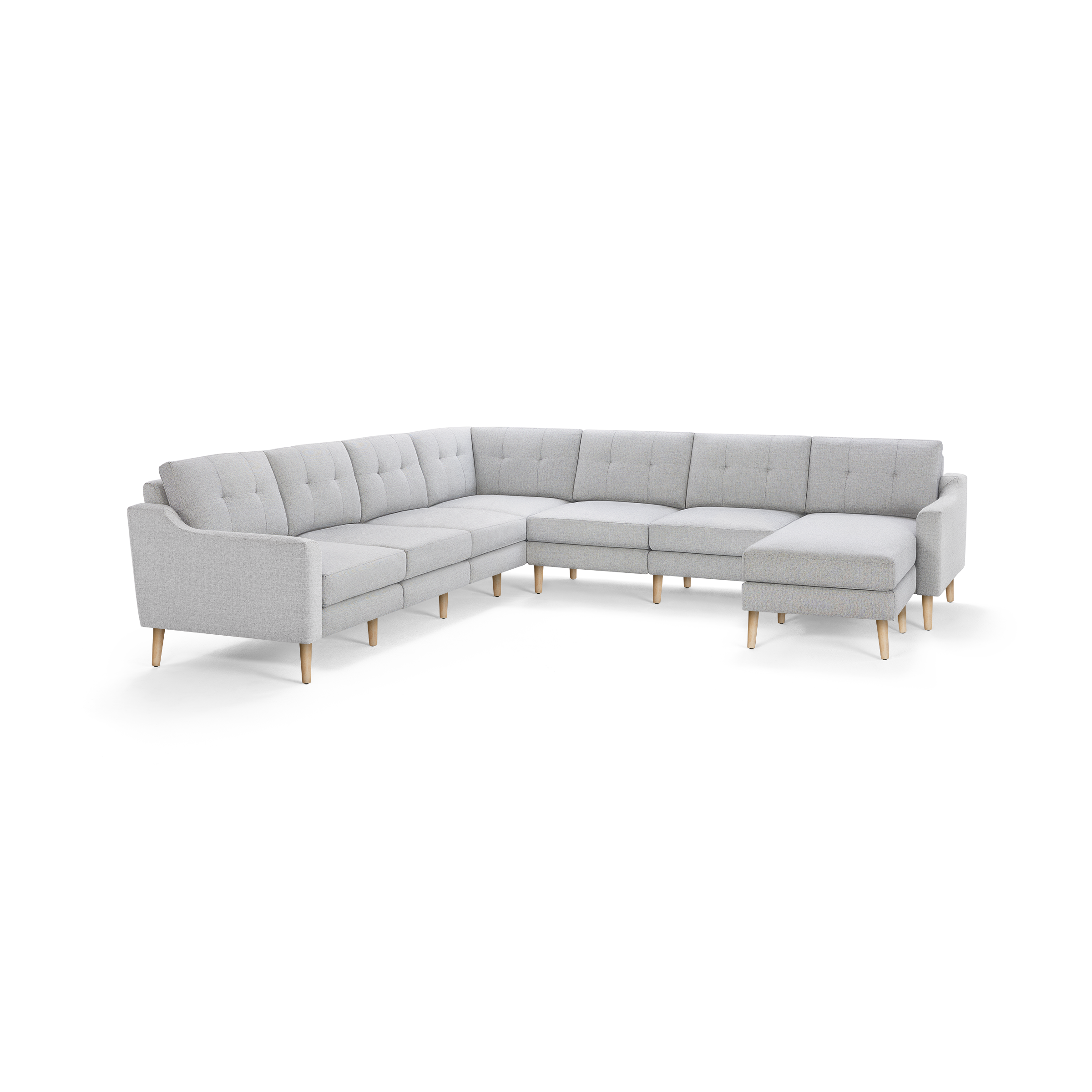 Light gray fabric sectional sofa with tufted back cushions, wooden legs, and an L-shape design with a chaise lounge on the right side.