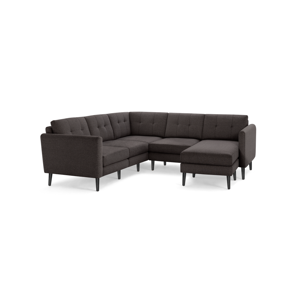 Dark gray fabric L-shaped sectional sofa with tufted cushions and slim black legs, modern and minimalist design.