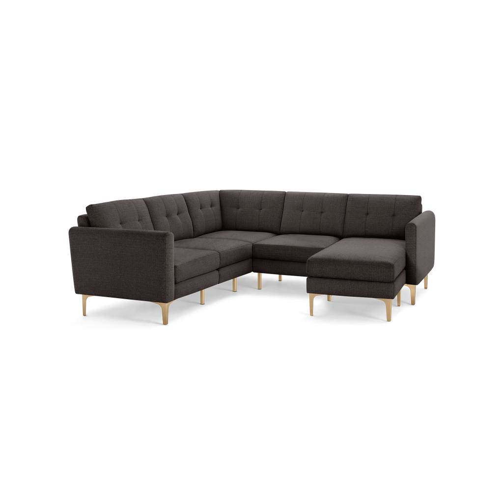 Dark gray L-shaped sectional sofa with tufted back cushions and gold metal legs, featuring a chaise lounge on the right side.