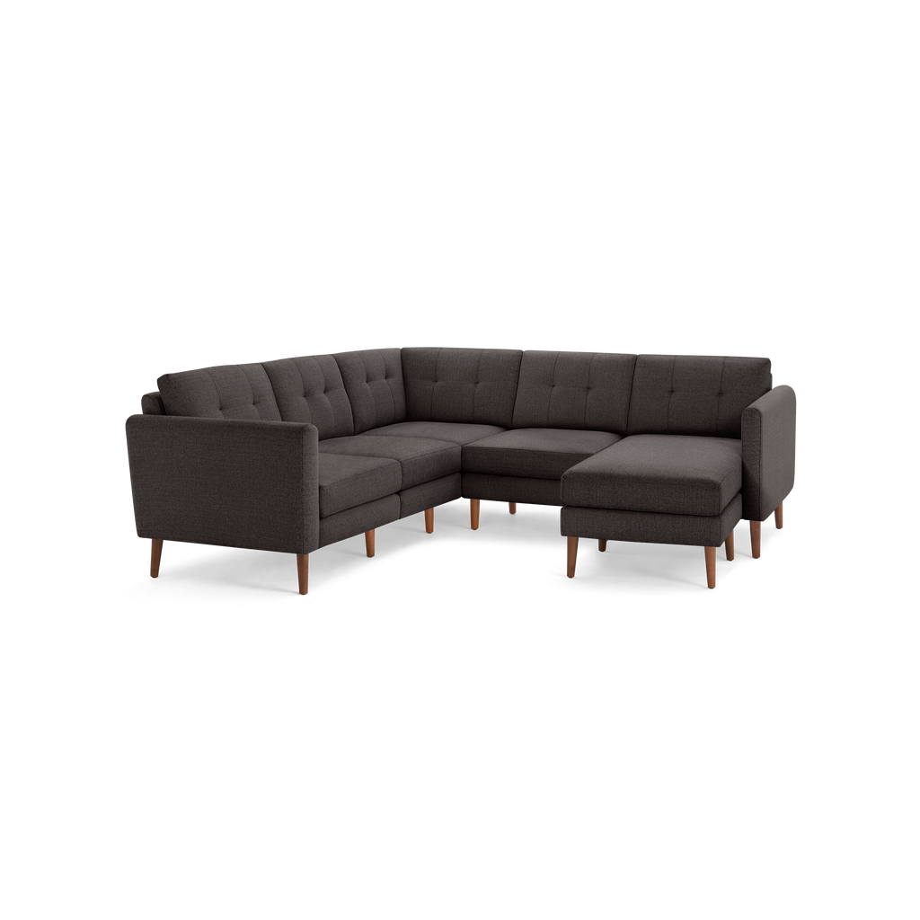 Dark gray upholstered L-shaped sectional sofa with tufted back cushions and wooden legs, designed for modern living spaces.