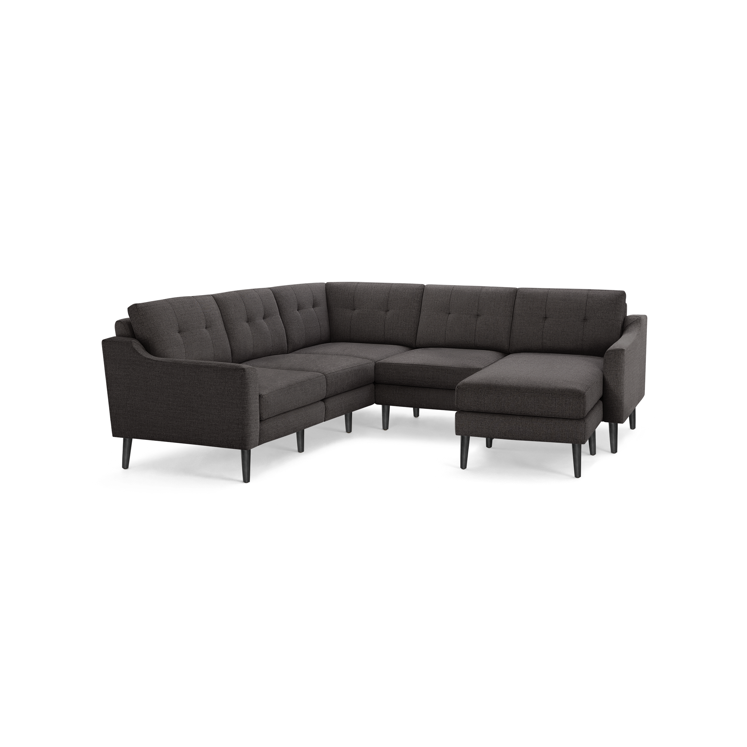 Dark gray upholstered fabric sectional sofa with tufted backrest, angled armrests, and slender black legs on black background.