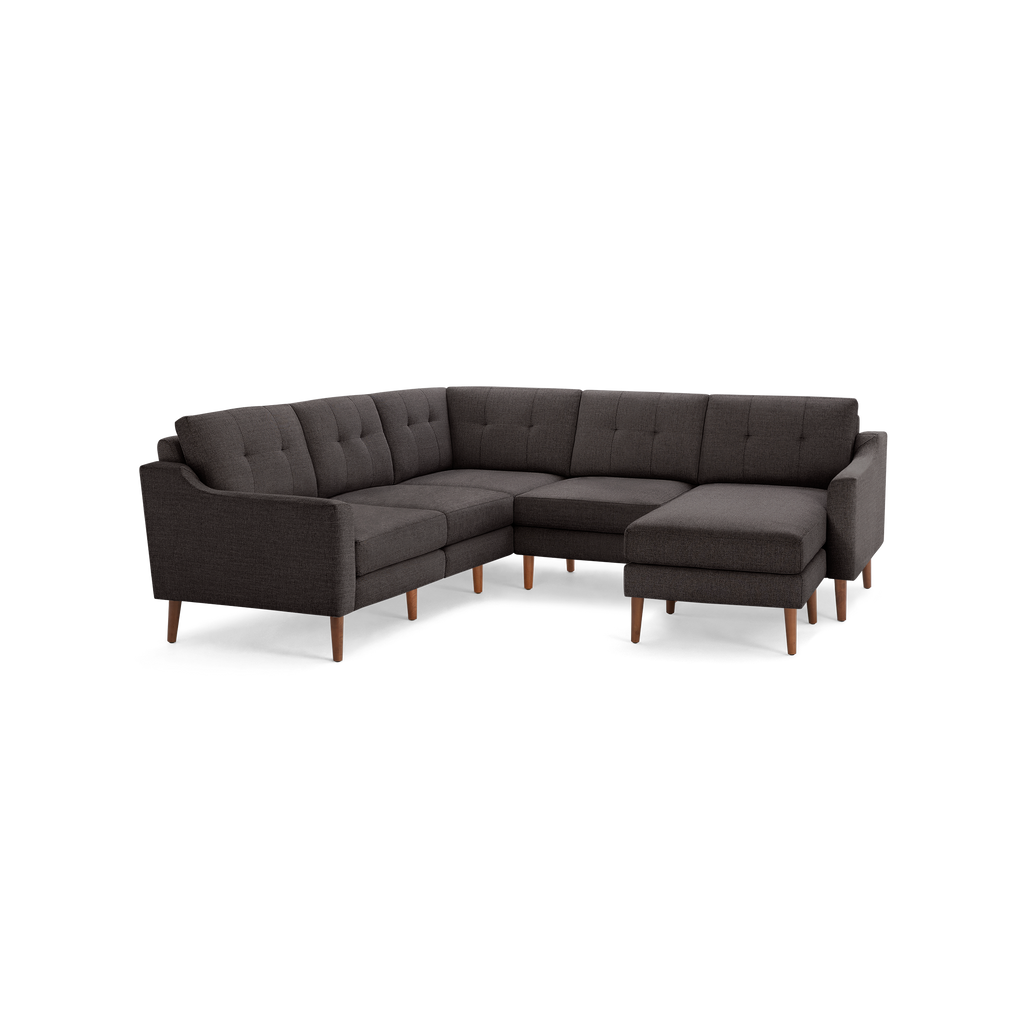 Dark gray fabric sectional sofa with tufted cushions, wooden legs, and a right-side chaise lounge.