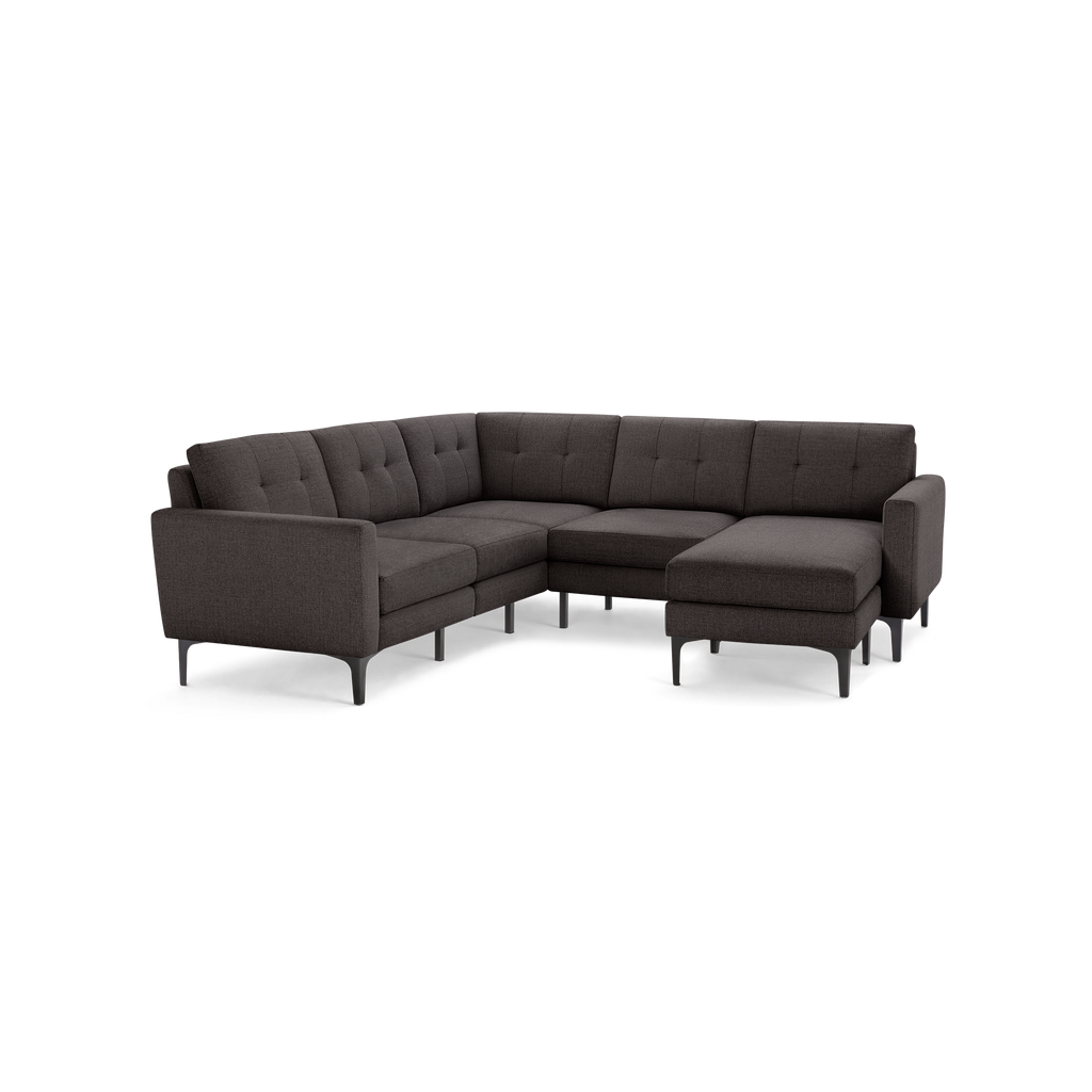 Dark gray upholstered sectional sofa with tufted cushions, modern metal legs, and chaise lounge on the right side.