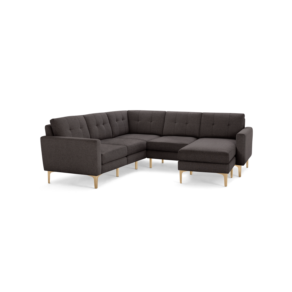 Dark gray L-shaped sectional sofa with tufted cushions and light wooden legs, designed for modern living spaces.