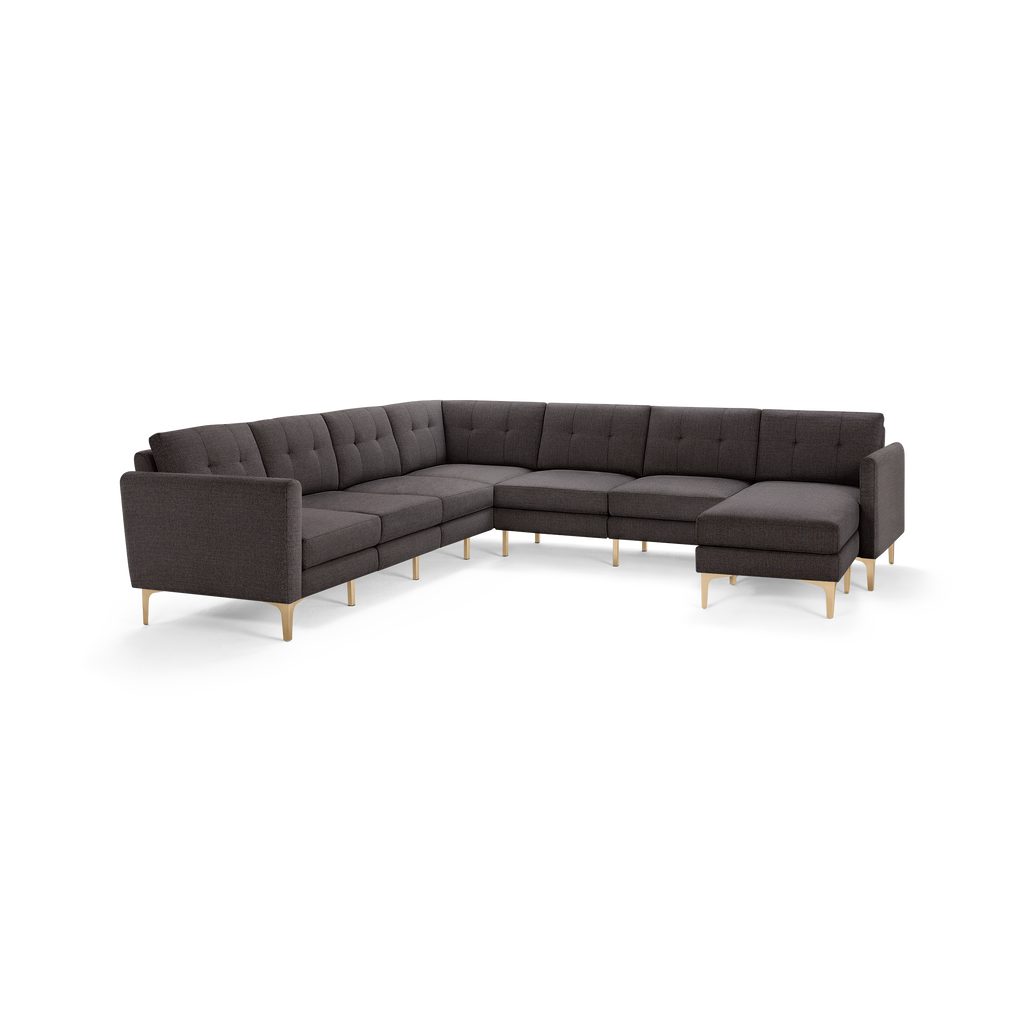 Large dark gray L-shaped sectional sofa with tufted back cushions and light wooden legs, modern design.