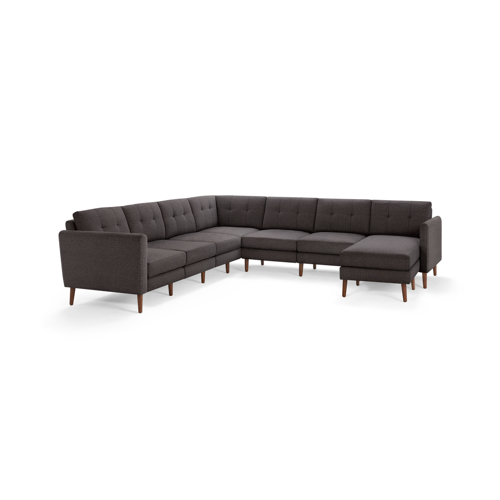 Dark gray fabric sectional sofa with tufted cushions, wooden legs, and an L-shaped design.