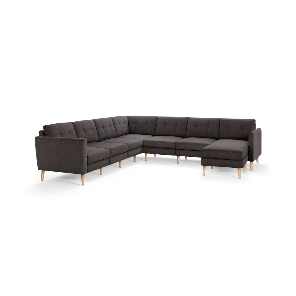 Dark gray L-shaped sectional sofa with tufted back cushions and light wooden legs, modern and minimalist design.