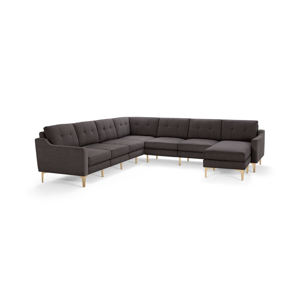 Dark gray L-shaped sectional sofa with tufted cushions and angled light wooden legs on a white background.