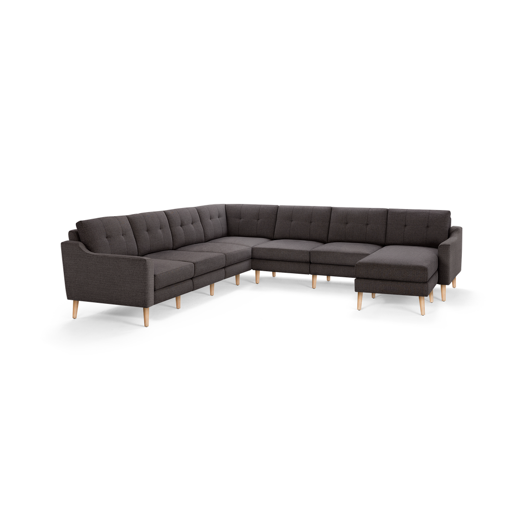 Dark gray L-shaped sectional sofa with button-tufted back cushions and light wooden legs.