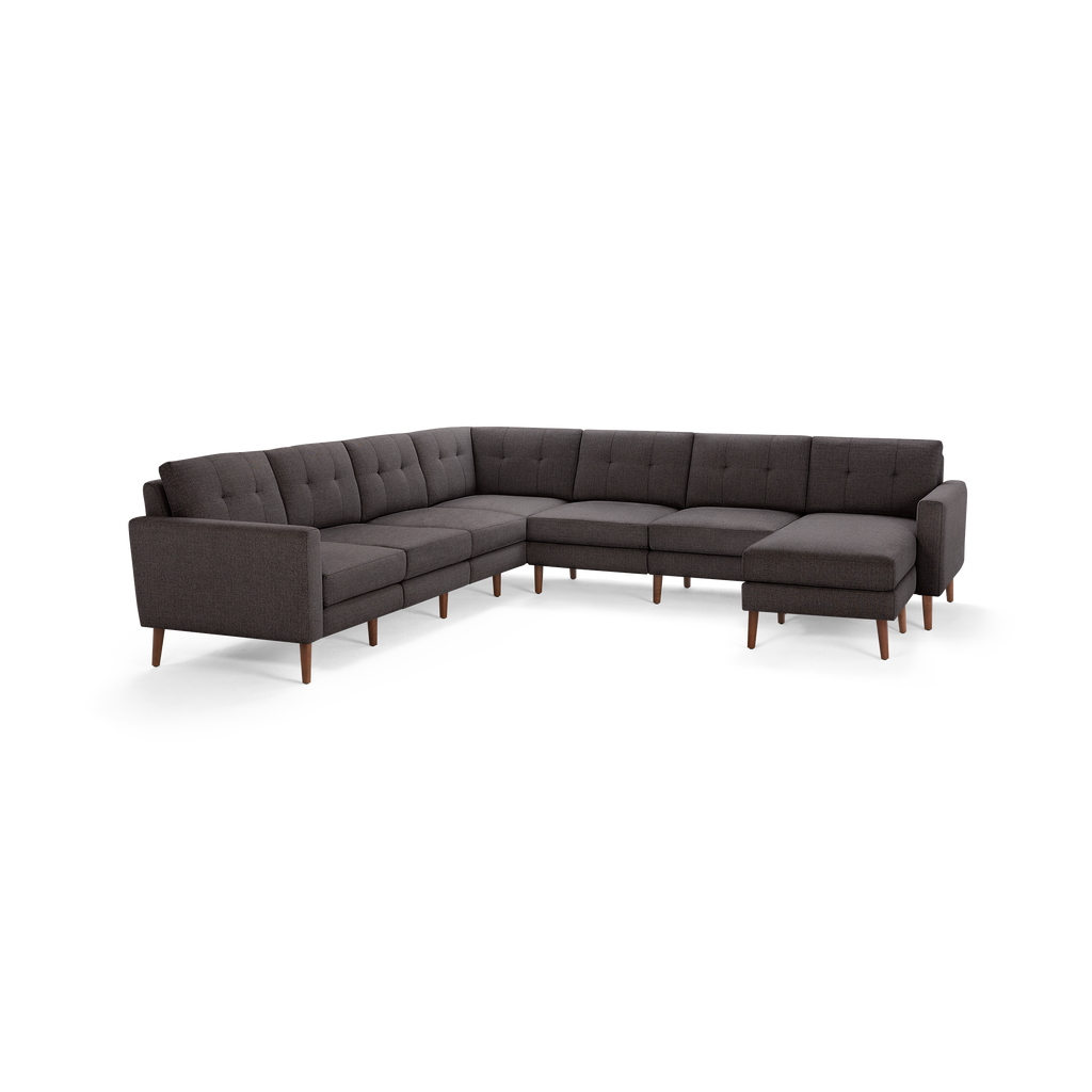 Dark gray L-shaped sectional sofa with tufted back cushions and wooden legs, featuring a chaise lounge on the right side.