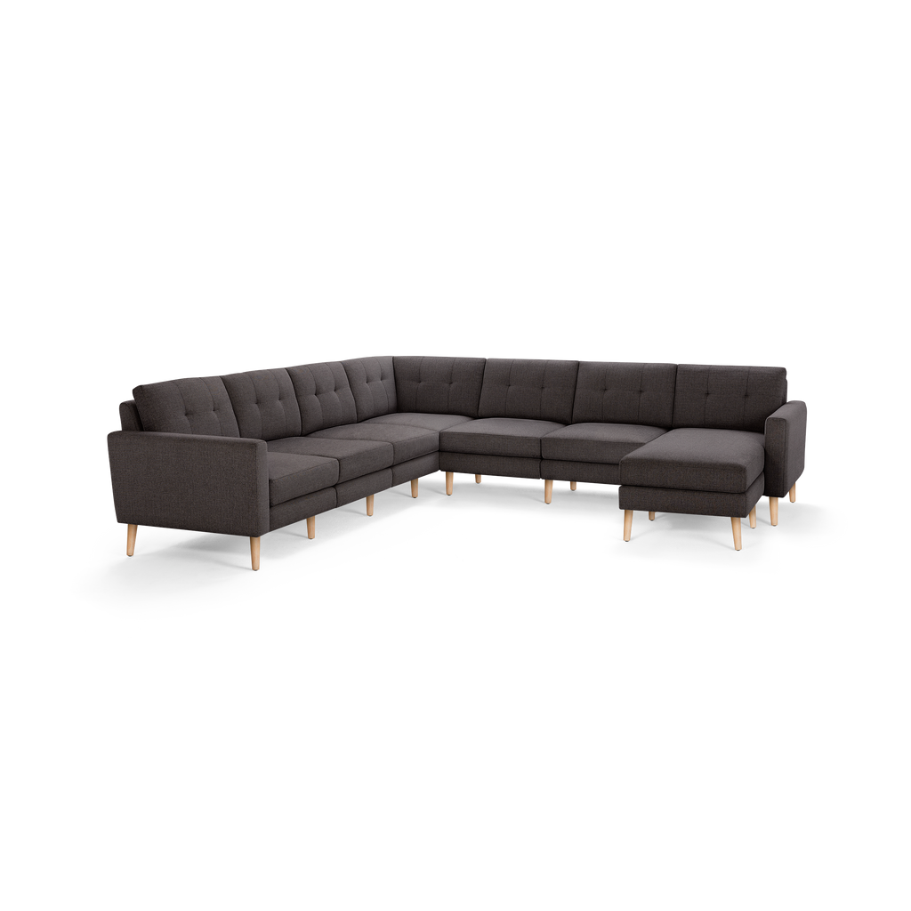 Dark gray fabric tufted L-shaped sectional sofa with wooden legs and right side chaise lounge.