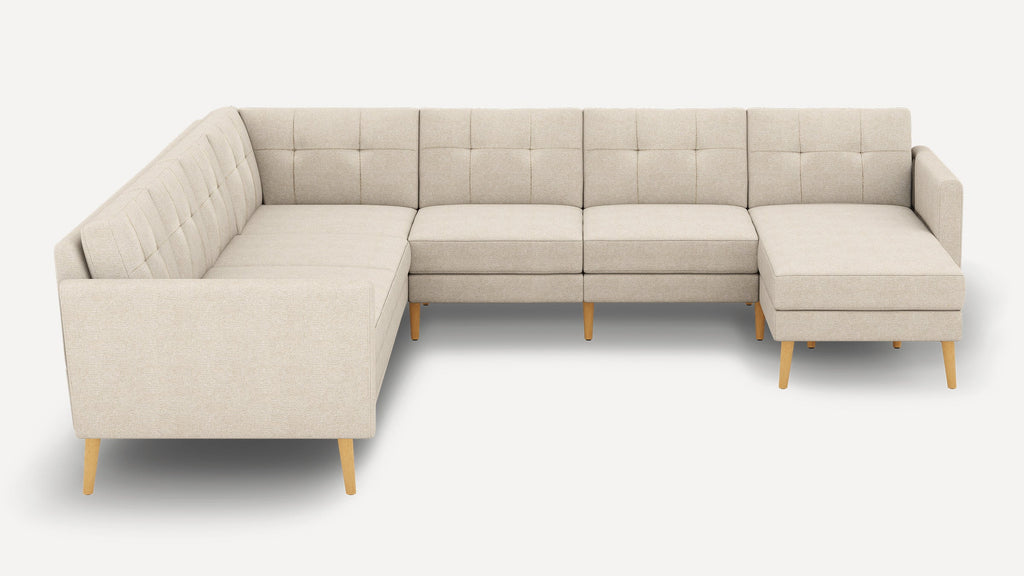 Beige L-shaped sectional sofa with tufted backrest, wooden legs, and clean, modern lines against a plain white background.