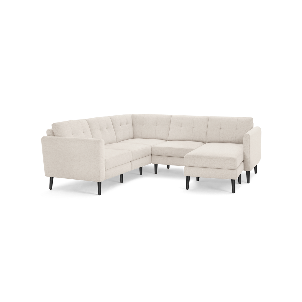 Light beige tufted fabric sectional sofa with black wooden legs, featuring an L-shaped design and modern style.