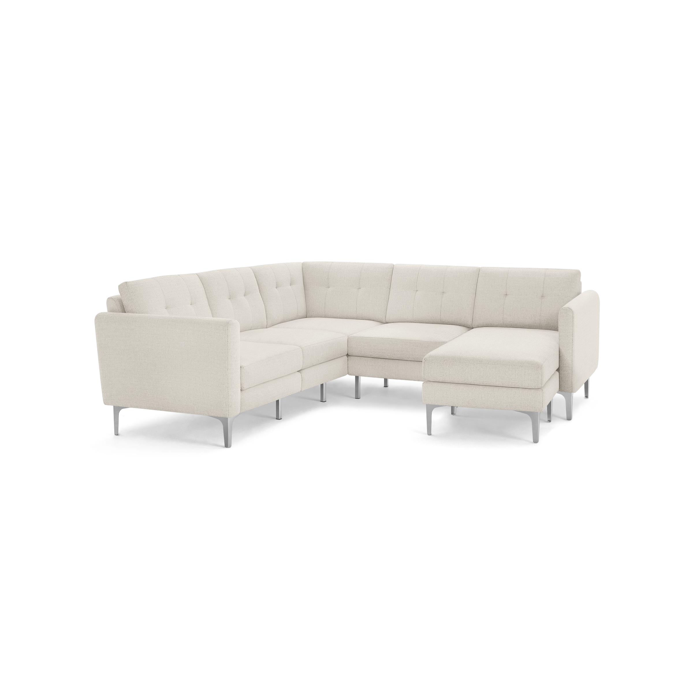 Modern L-shaped sectional sofa in light beige fabric with tufted back cushions and slim metal legs, featuring a chaise lounge on the right side.
