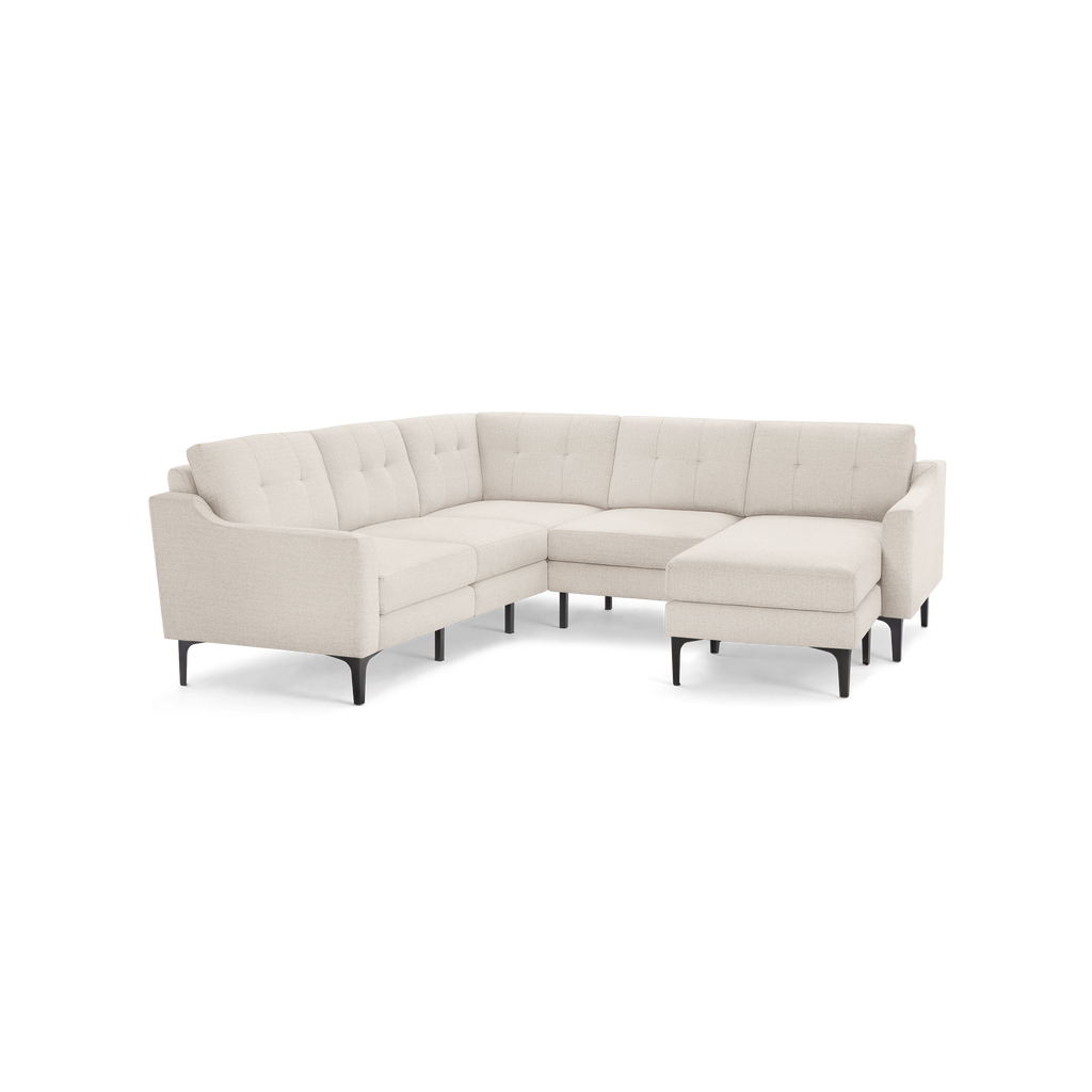 Beige fabric sectional sofa with tufted cushions, right-side chaise, slim black legs, and a modern minimalist design.