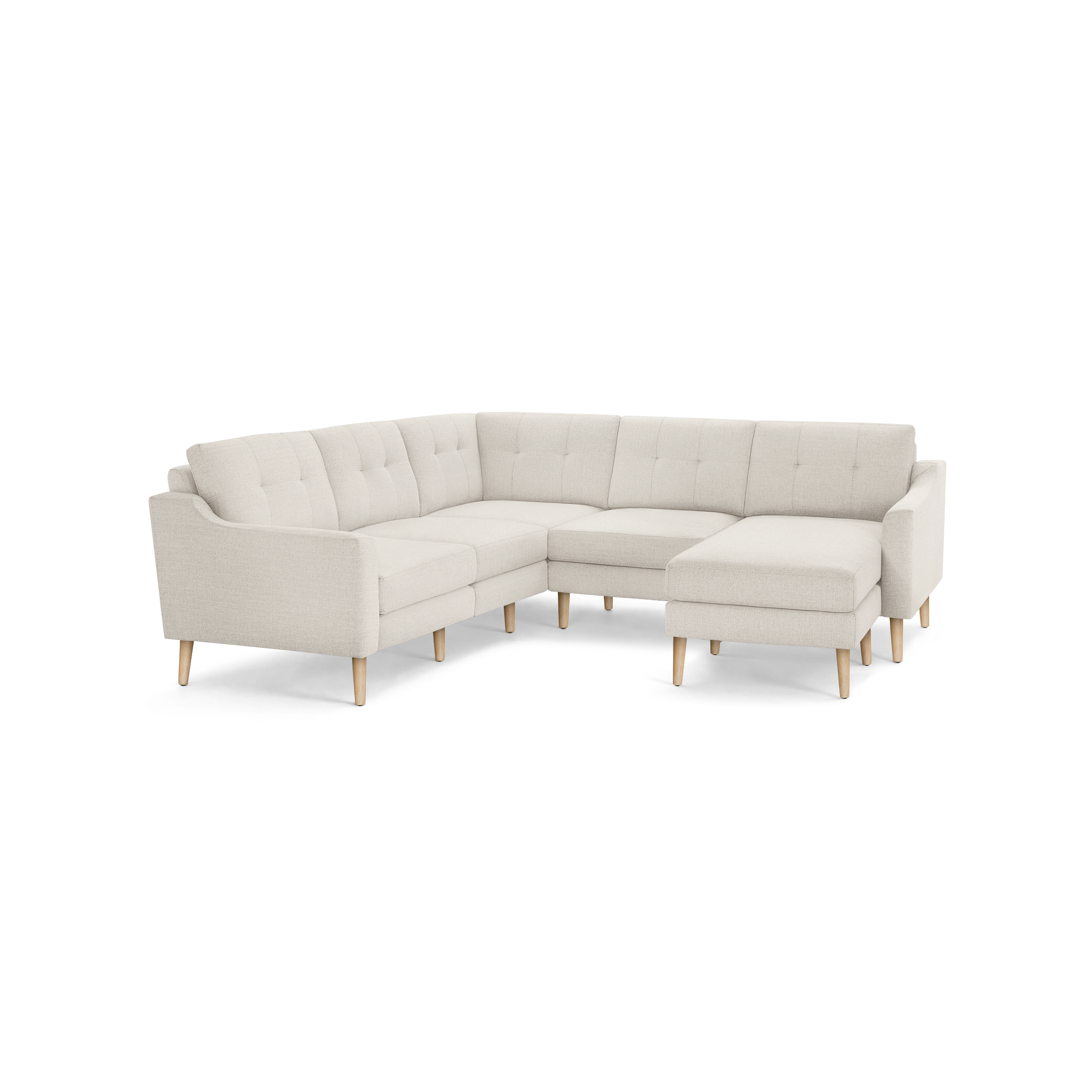 Light beige fabric sectional sofa with tufted back cushions, wooden legs, and a modern mid-century design.
