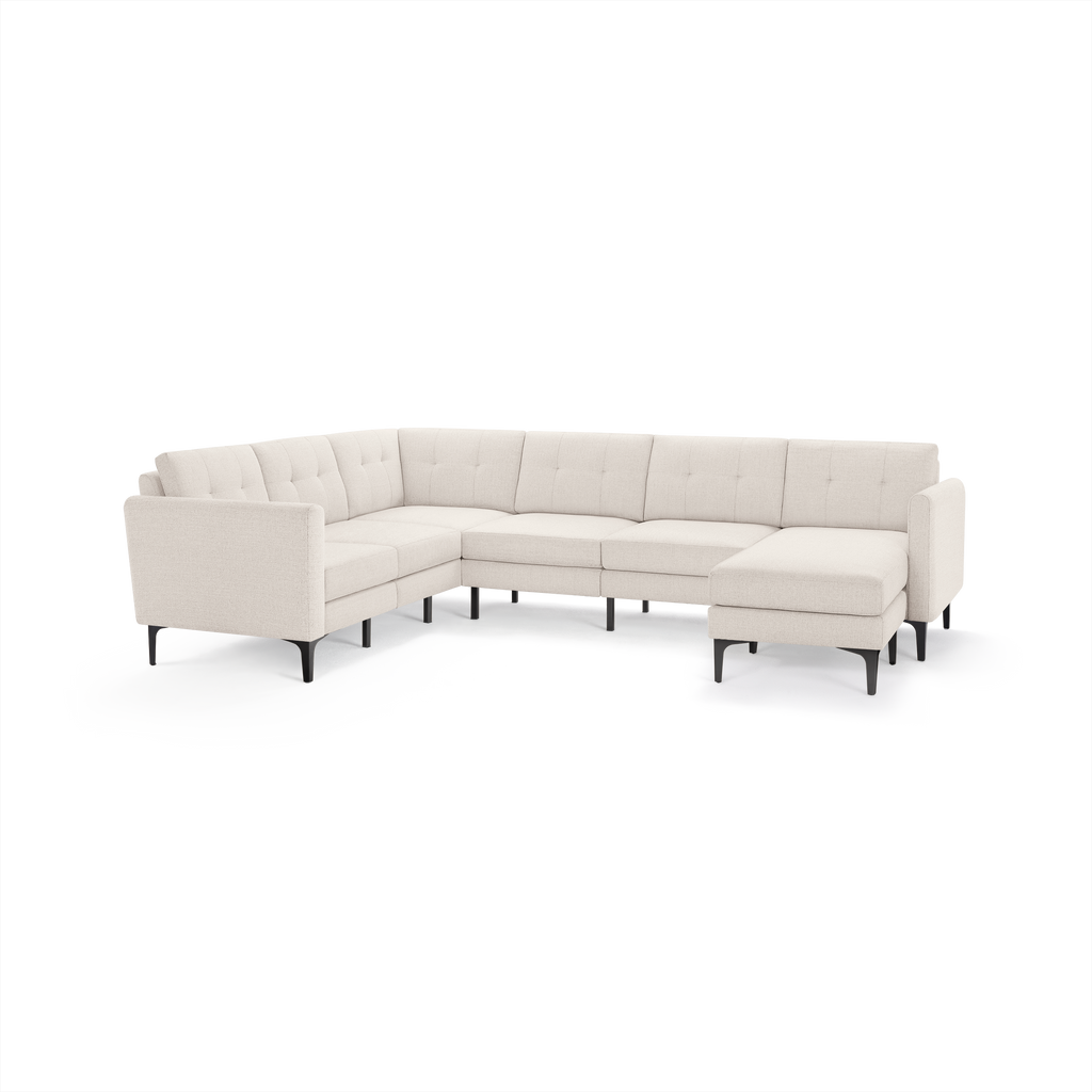 Light beige fabric sectional sofa with tufted back cushions and black metal legs, featuring an L-shaped design.