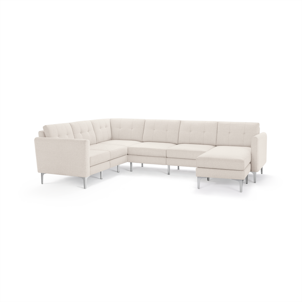 Modern L-shaped sectional sofa in light beige fabric with tufted cushions and metal legs, featuring a chaise lounge on the right side.