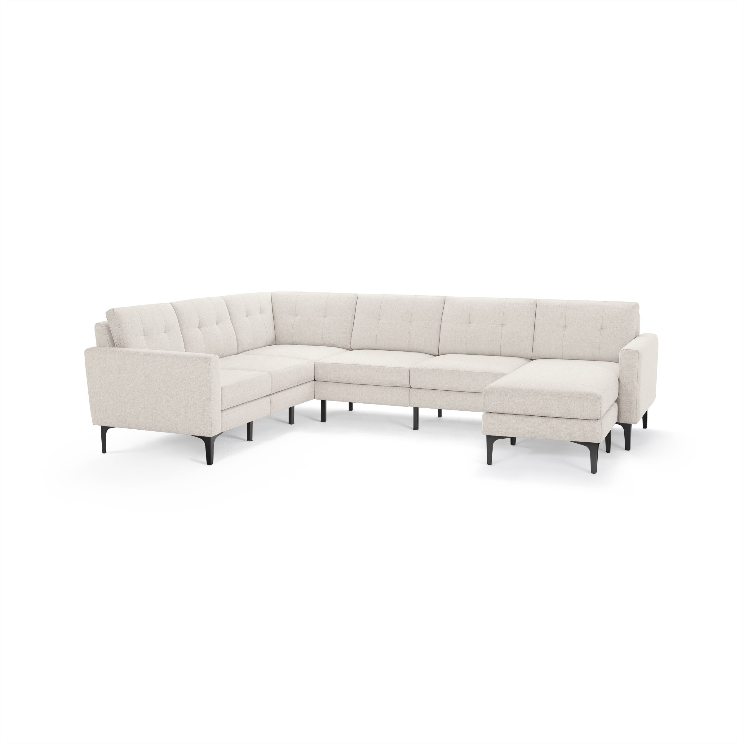 Light beige modern sectional sofa with tufted back cushions, thin black legs, and a chaise lounge on the right side.