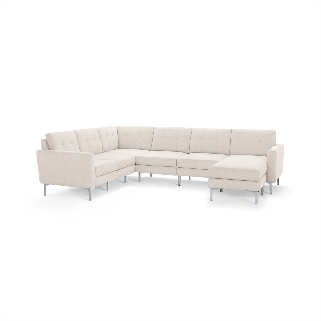 Modern L-shaped beige fabric sectional sofa with tufted back cushions and slim metal legs, offering spacious seating and a chaise lounge.