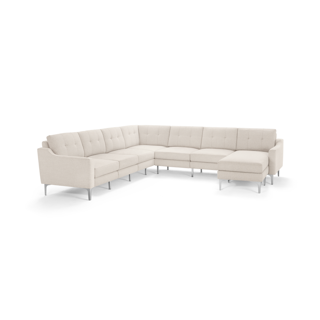 Large L-shaped sectional sofa with beige fabric upholstery, tufted cushions, and sleek metal legs, featuring a chaise lounge on one end.