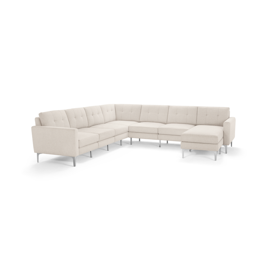 Modern L-shaped beige fabric sectional sofa with tufted back cushions and slim metal legs.