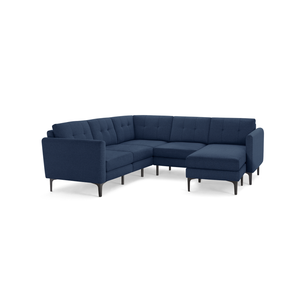 Modern L-shaped sectional sofa with deep navy blue fabric upholstery, tufted back cushions, and slim black metal legs.