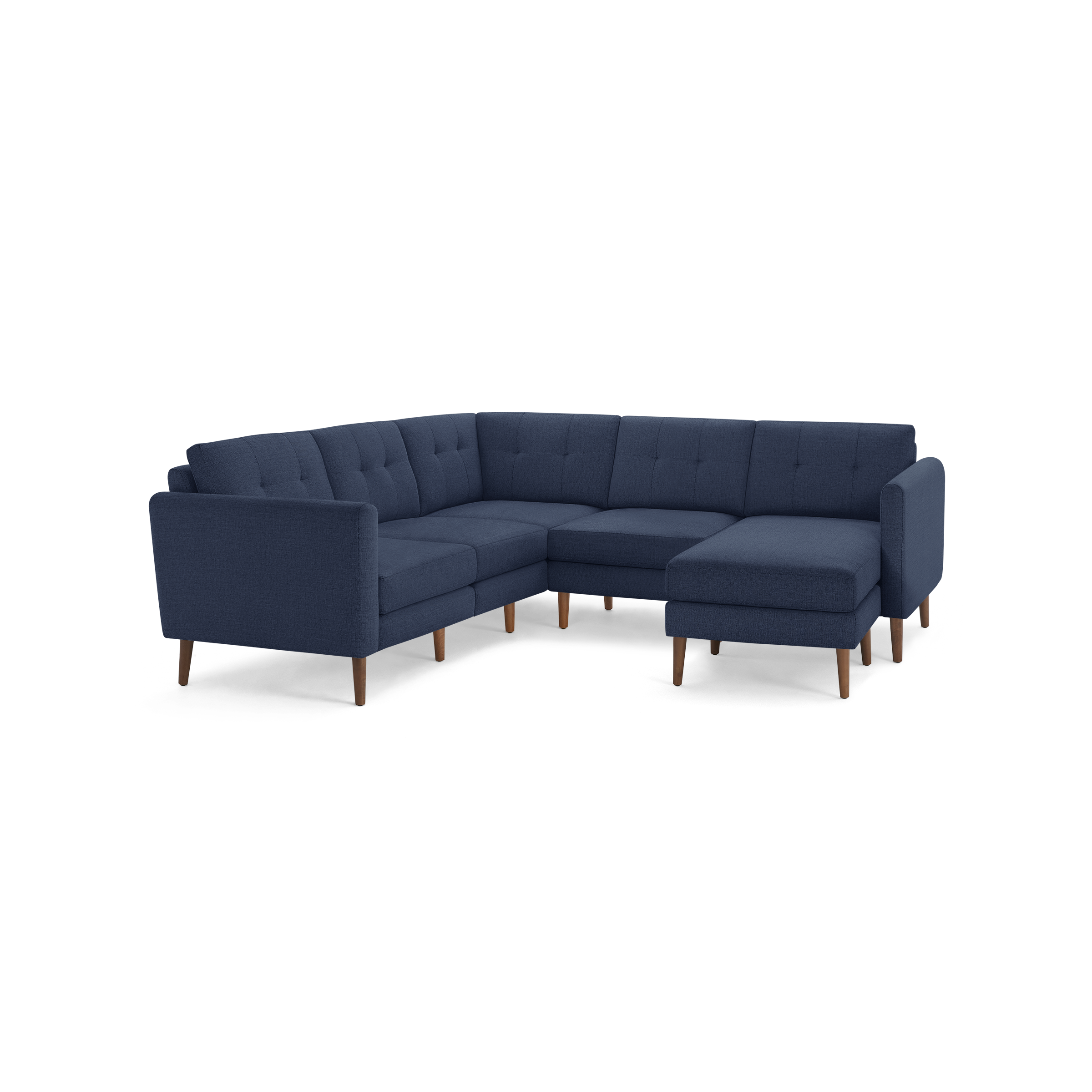 Large L-shaped sectional sofa in dark blue fabric with tufted cushions and tapered wooden legs.