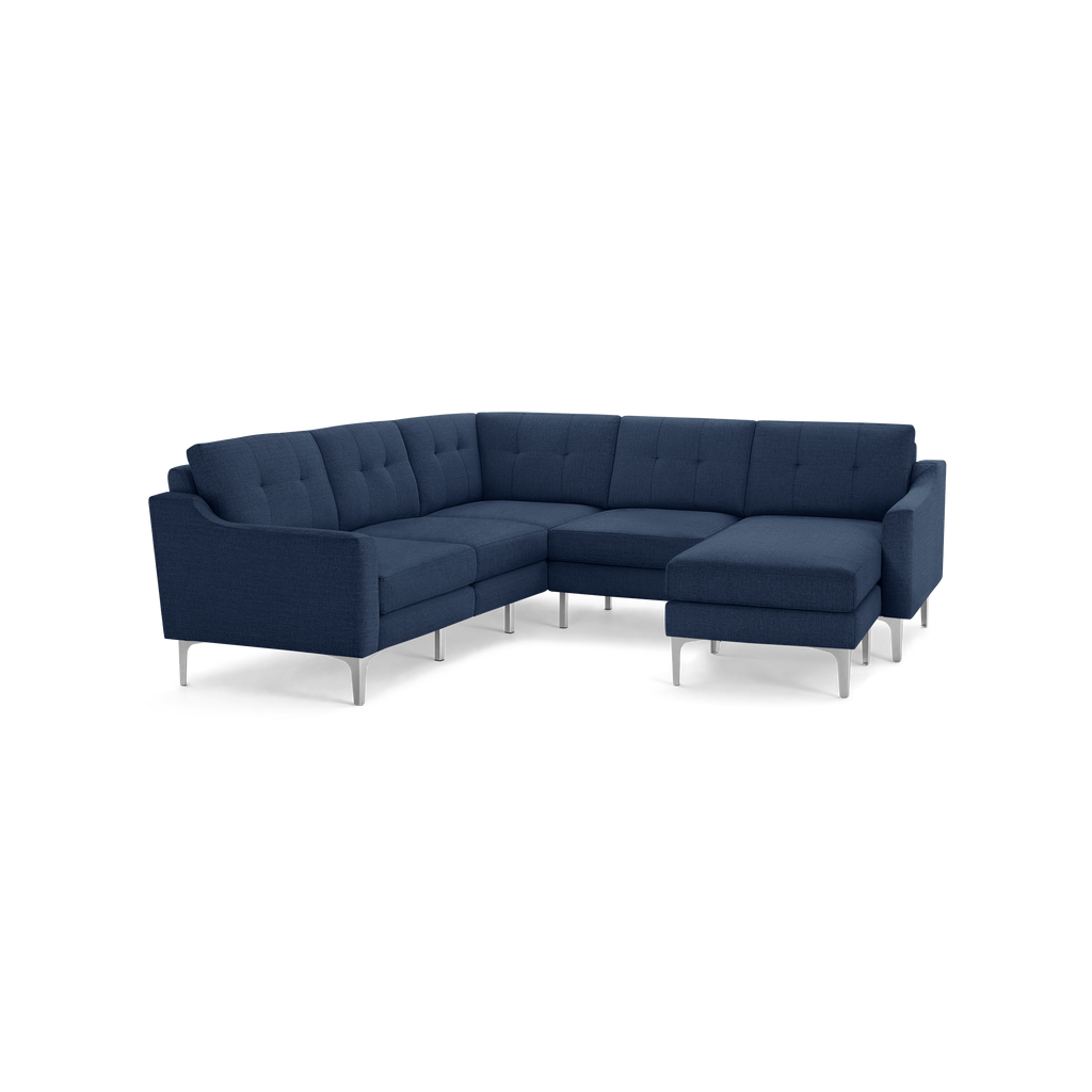 Modern navy blue fabric sectional sofa with tufted cushions and sleek silver metal legs, featuring an L-shaped design and a chaise lounge.