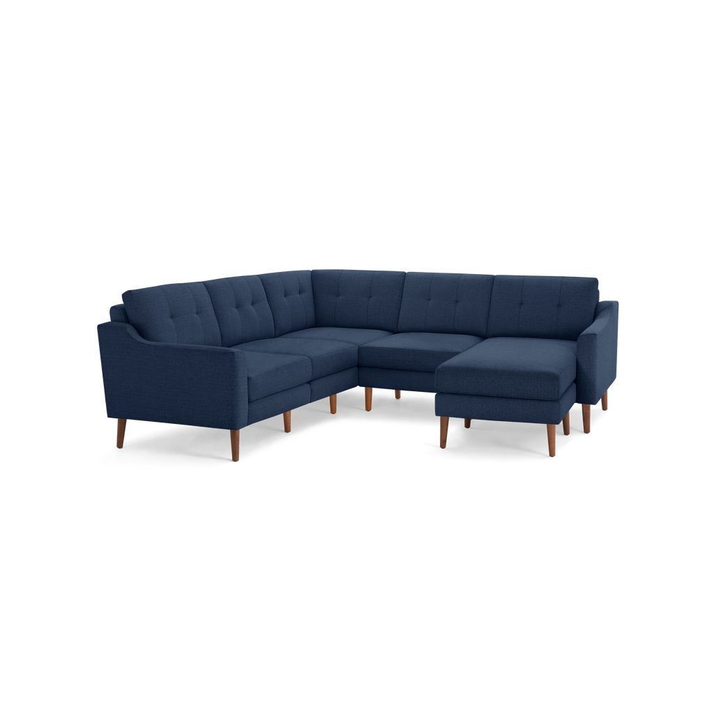 Modern navy blue sectional sofa with tufted cushions and wooden legs, featuring a right-side chaise lounge for extra comfort.