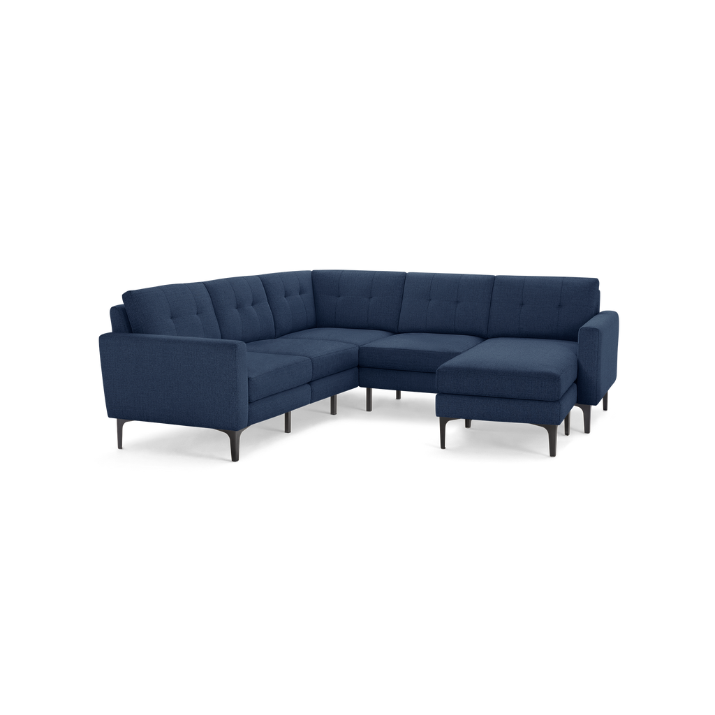 Alt text: Modern L-shaped sectional sofa in dark blue fabric, featuring tufted back cushions and sleek black legs.