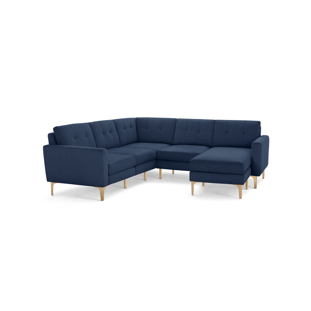 Modern navy blue sectional sofa with tufted back cushions and light wooden legs, featuring a right-facing chaise lounge.