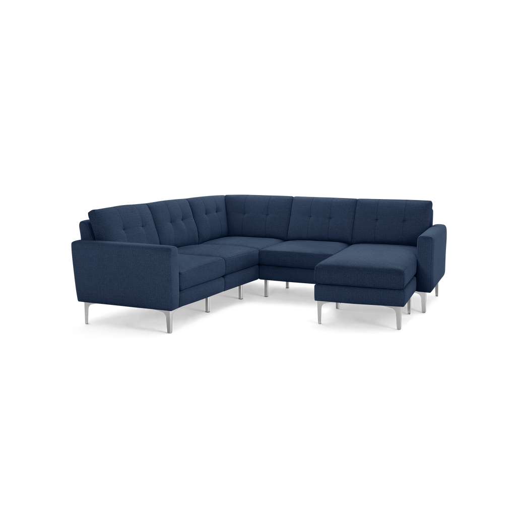 Modern navy blue fabric L-shaped sectional sofa with tufted back cushions and sleek metal legs.