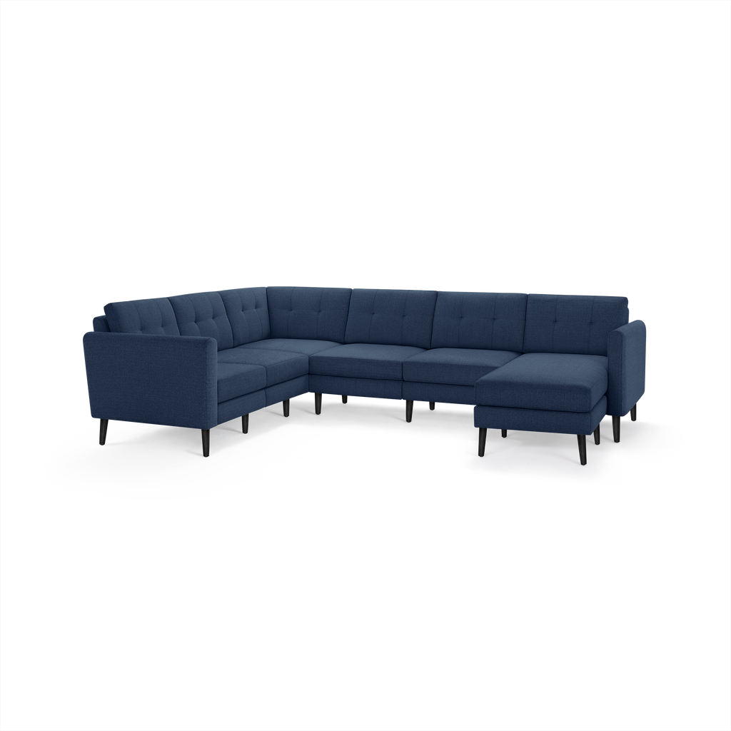 Modern navy blue fabric sectional sofa with tufted backrest, L-shape design, and black tapered wooden legs.