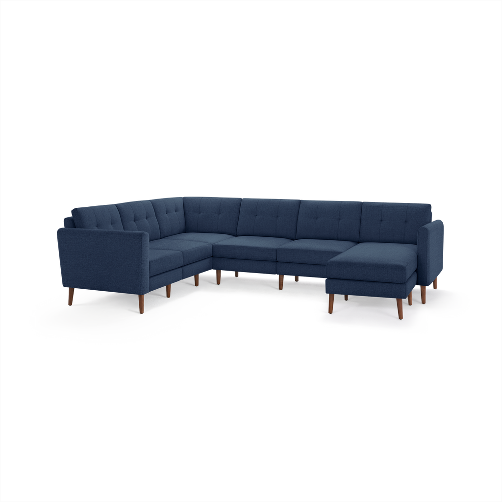 Modern navy blue fabric sectional sofa with tufted cushions, wooden legs, and a right-side chaise lounge.