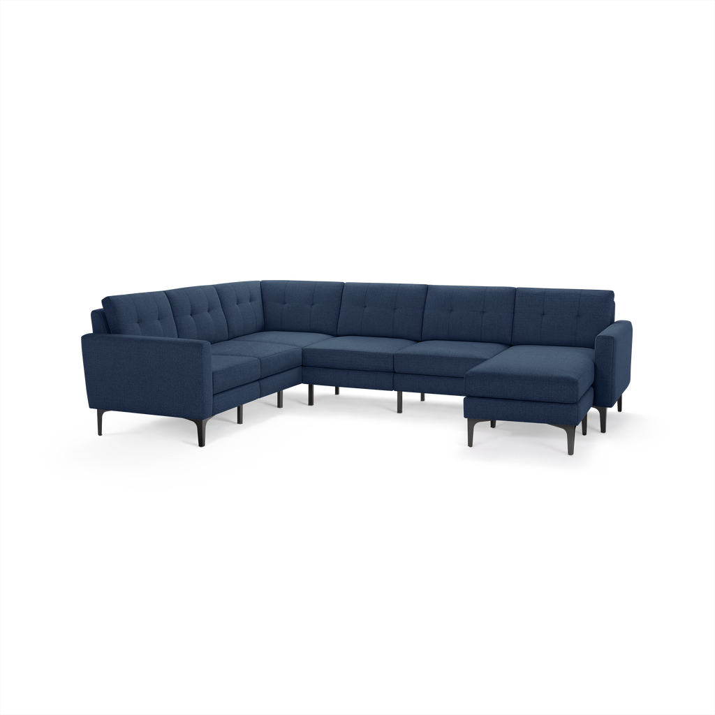 Modern L-shaped sectional sofa upholstered in navy blue fabric with tufted cushions and black tapered legs.
