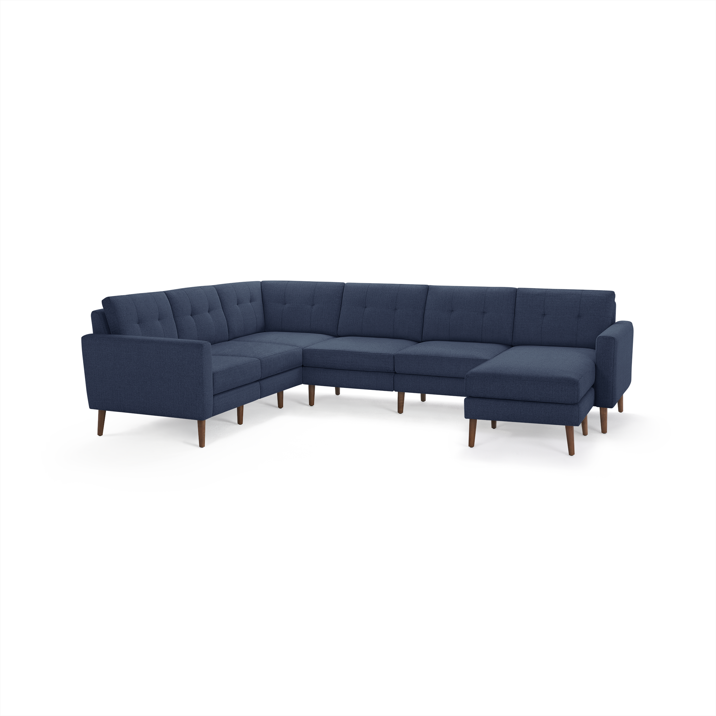 Large navy blue fabric sectional sofa with tufted cushions, wooden legs, and an L-shaped design with chaise lounge on the right side.