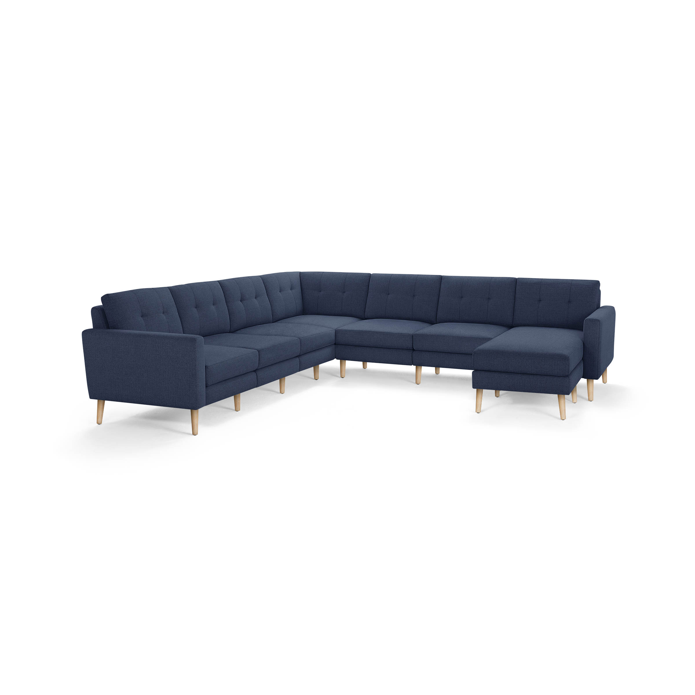 Large modern L-shaped sectional sofa in dark blue fabric with tufted back cushions and light wooden legs.