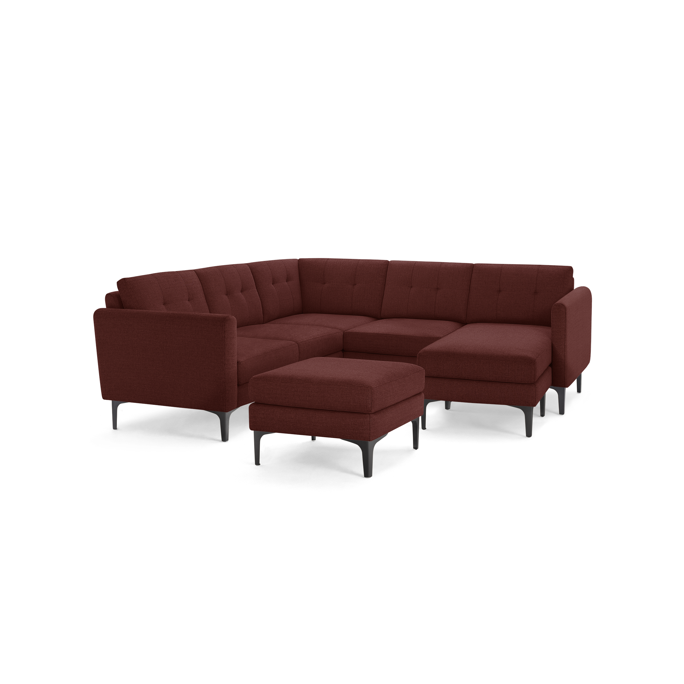 Modern L-shaped sectional sofa in deep red fabric with tufted cushions, slim black legs, and matching ottoman.