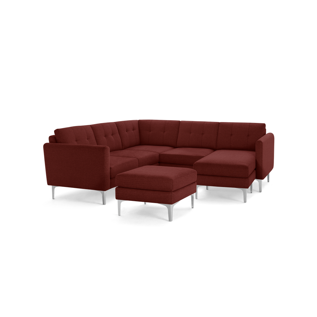 Modern rust-colored sectional sofa with tufted cushions, a matching ottoman, and sleek metal legs designed for spacious comfort.