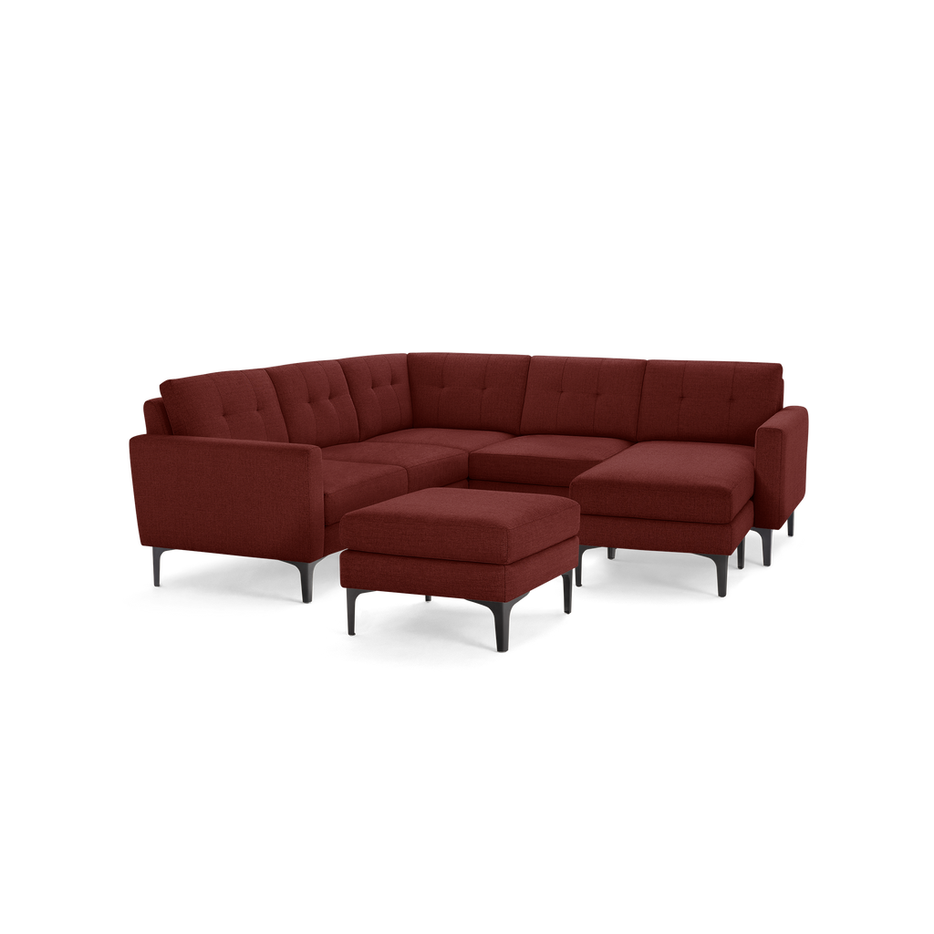 Modern L-shaped sectional sofa with tufted cushions, deep red fabric upholstery, metal legs, and matching ottoman.