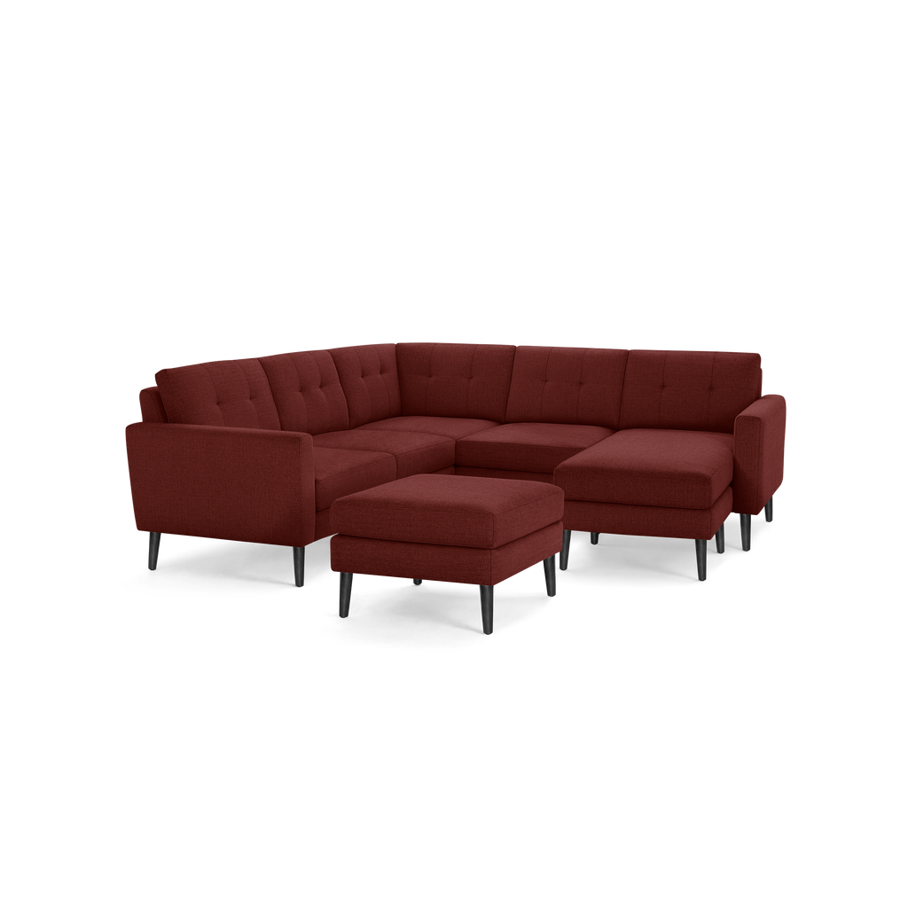 Modern sectional sofa set with dark red fabric upholstery, button tufting, angled armrests, black tapered wooden legs, and matching ottoman.