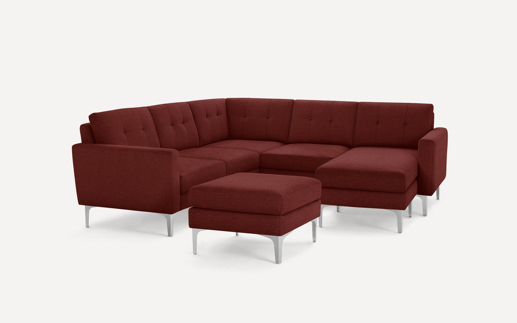 Modern burgundy sectional sofa with tufted cushions, straight armrests, chrome legs, and a matching ottoman on a white background.