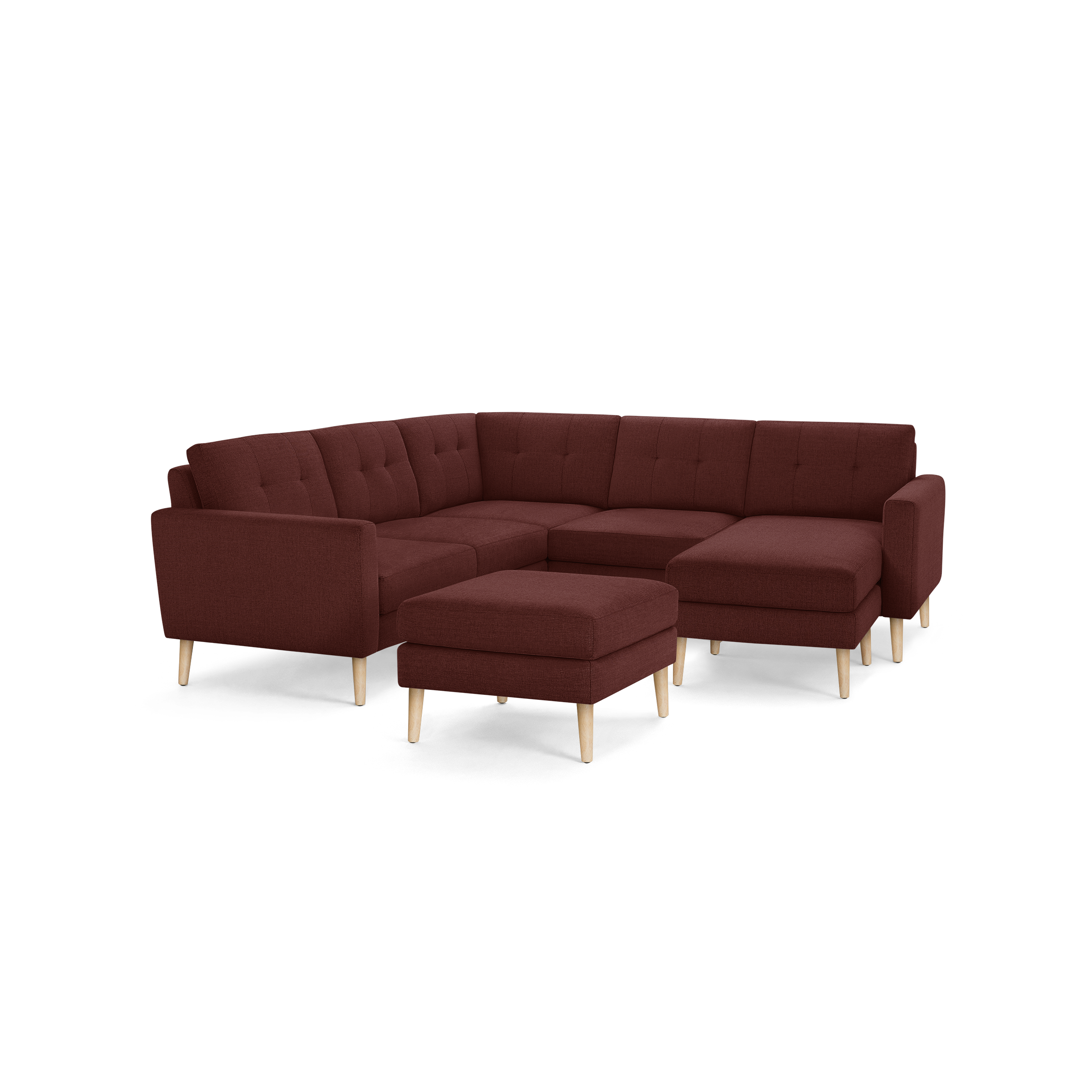 Modern L-shaped sectional sofa in deep burgundy fabric with tufted back cushions and light wooden legs, includes matching ottoman.