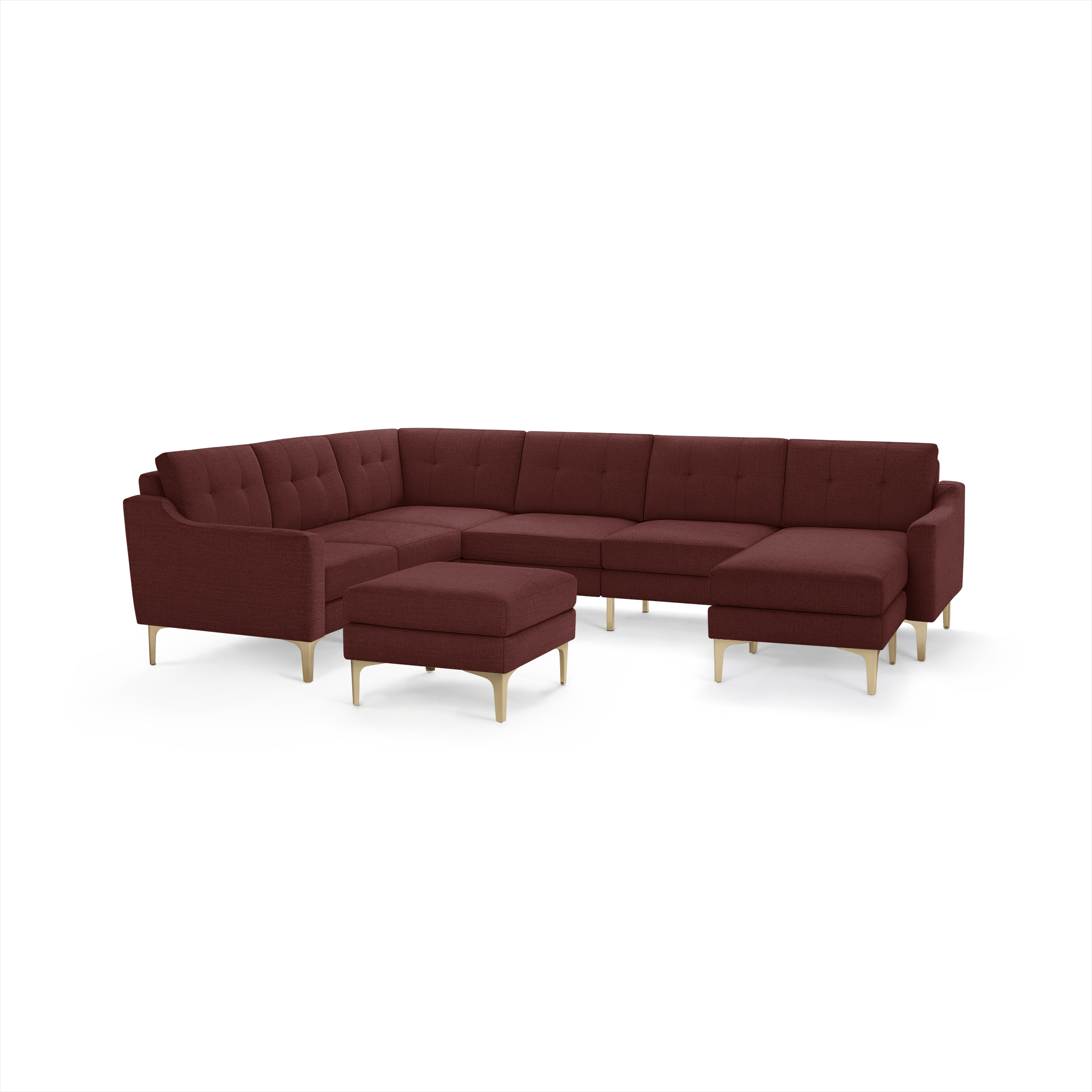Large L-shaped sectional sofa in deep red fabric with tufted cushions, curved armrests, and light wooden legs, including a matching ottoman.