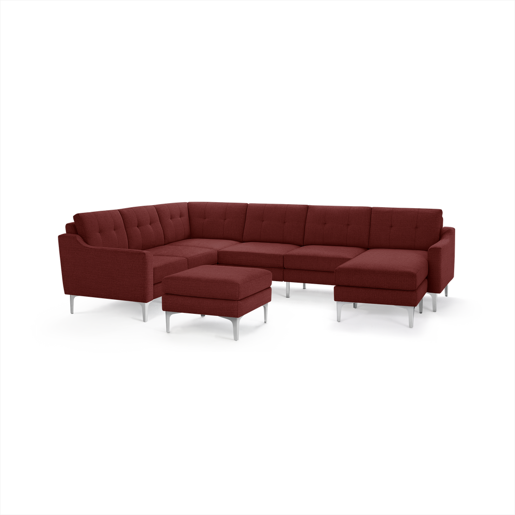 Modern L-shaped sectional sofa in deep red fabric with button-tufted cushions and matching ottoman on silver metal legs.
